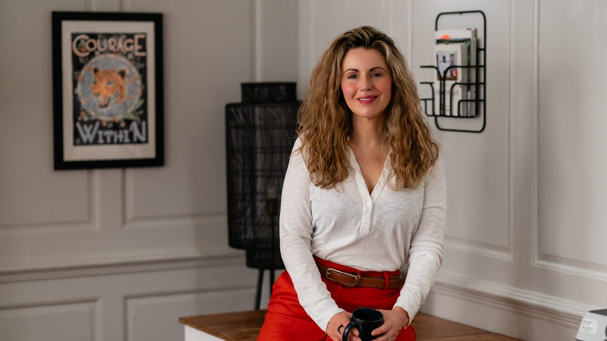 Karlina Jordan sitting calmly in her room beside a 'Courage Within' print